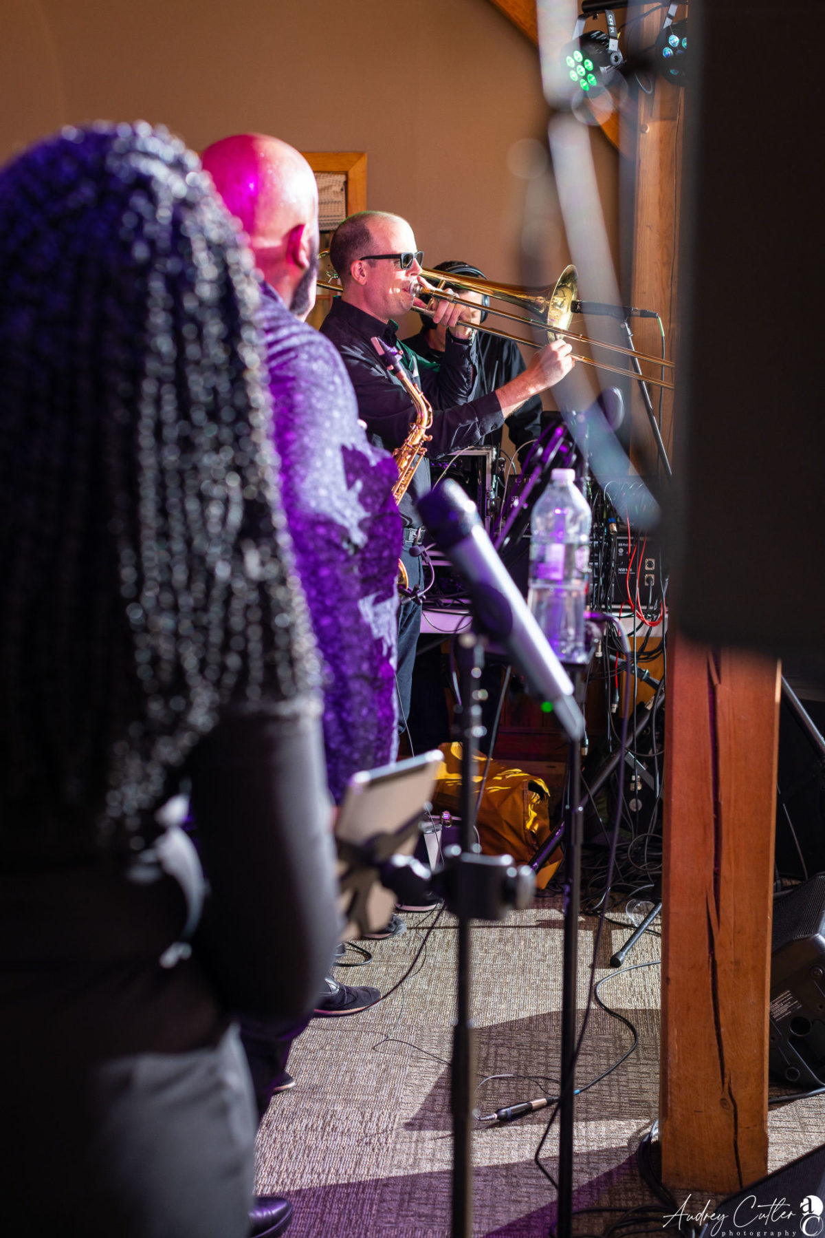 Live band performing at Harrington Farm wedding with trombone, saxophone, and vocalist on stage.
