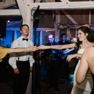 Bride and guests dancing joyfully at rustic Marianmade Farm wedding in Wiscasset, Maine.