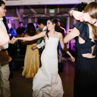 Bride dancing joyfully with guests at Marianmade Farm wedding in Wiscasset, Maine.