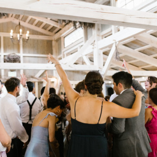 Guests dancing and celebrating at a rustic barn wedding reception in Wiscasset, Maine.