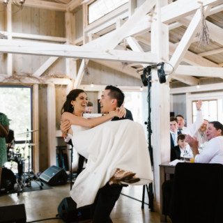 Groom lifting joyful bride during rustic Marianmade Farm wedding celebration in Wiscasset, Maine.