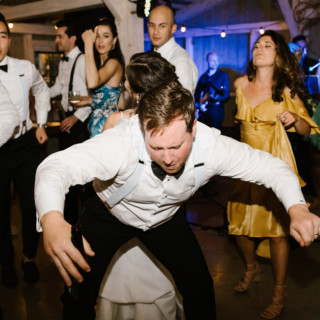 Groom dancing joyfully with guests at Marianmade Farm wedding in Wiscasset, Maine.