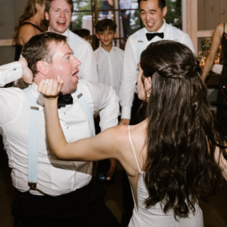 Bride and groom share a joyful dance at their rustic Marianmade Farm wedding in Maine.