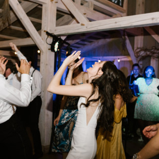 Bride and guests dancing joyfully under warm string lights at Marianmade Farm wedding in Maine.