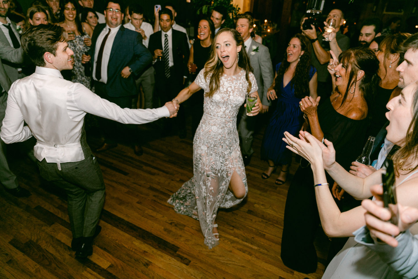 Bride and groom dancing joyfully at Migis Lodge wedding surrounded by cheering guests in South Casco.