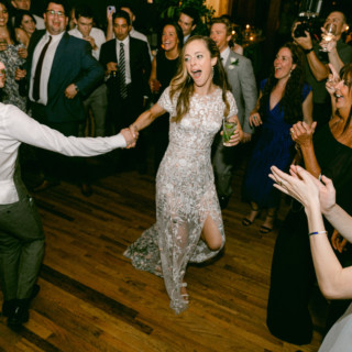 Bride and groom dancing joyfully at Migis Lodge wedding surrounded by cheering guests in South Casco.