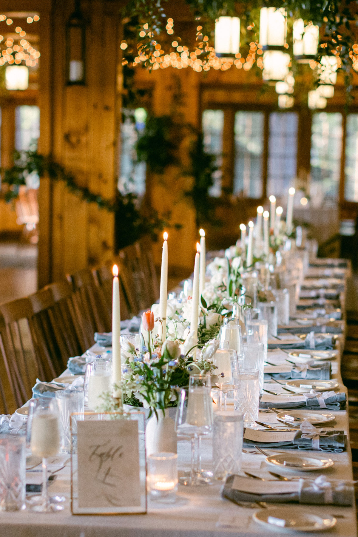 Elegant rustic wedding table with candles and white flowers at Migis Lodge in Maine.