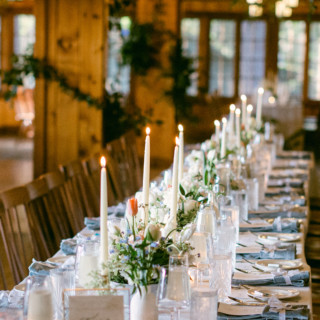 Elegant rustic wedding table with candles and white flowers at Migis Lodge in Maine.