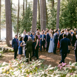 Elegant outdoor wedding reception under pine trees at Migis Lodge in South Casco, Maine.