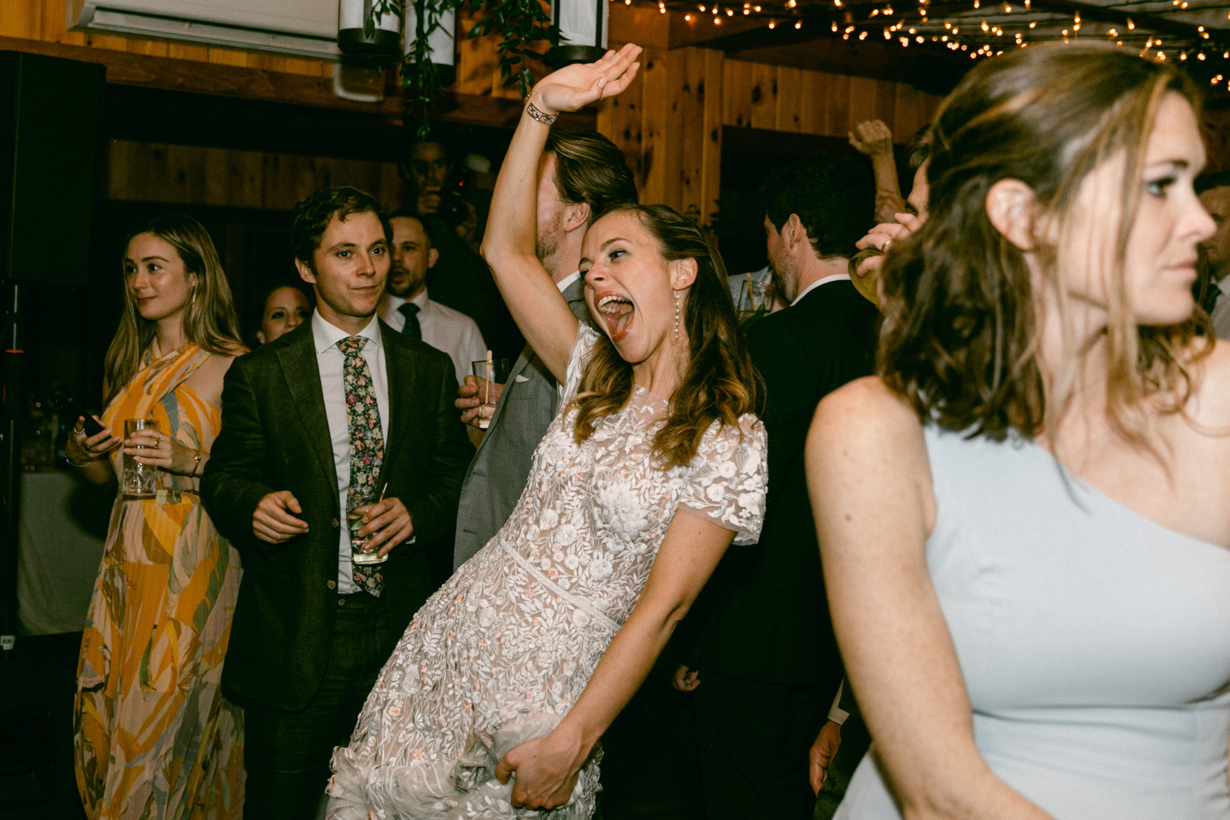 Bride dancing joyfully at Migis Lodge wedding reception in South Casco, Maine.