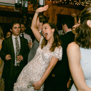 Bride dancing joyfully at Migis Lodge wedding reception in South Casco, Maine.