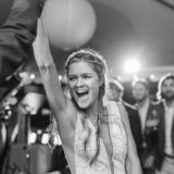 Joyful bride laughing and dancing with groom during black-and-white wedding celebration in Marblehead, MA.