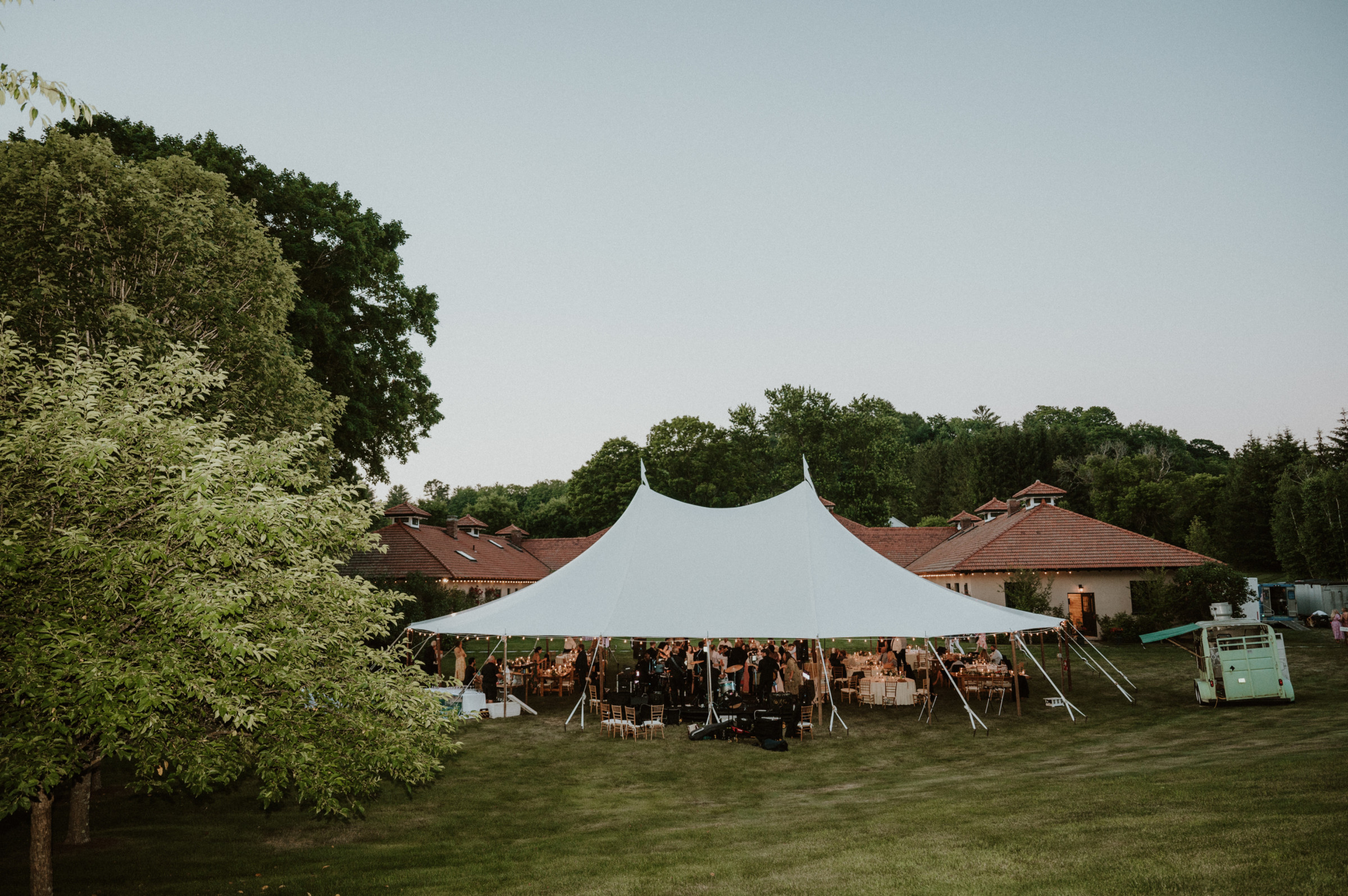 Elegant outdoor wedding reception under a white tent on a scenic Vermont farm estate.