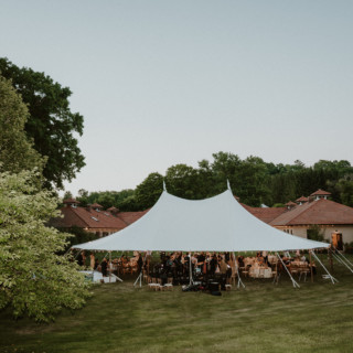 Elegant outdoor wedding reception under a white tent on a scenic Vermont farm estate.
