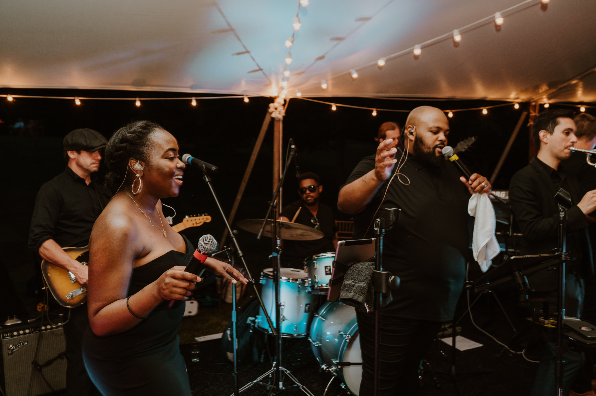 Live wedding band performing under glowing string lights at River Road Farm in Manchester, Vermont.