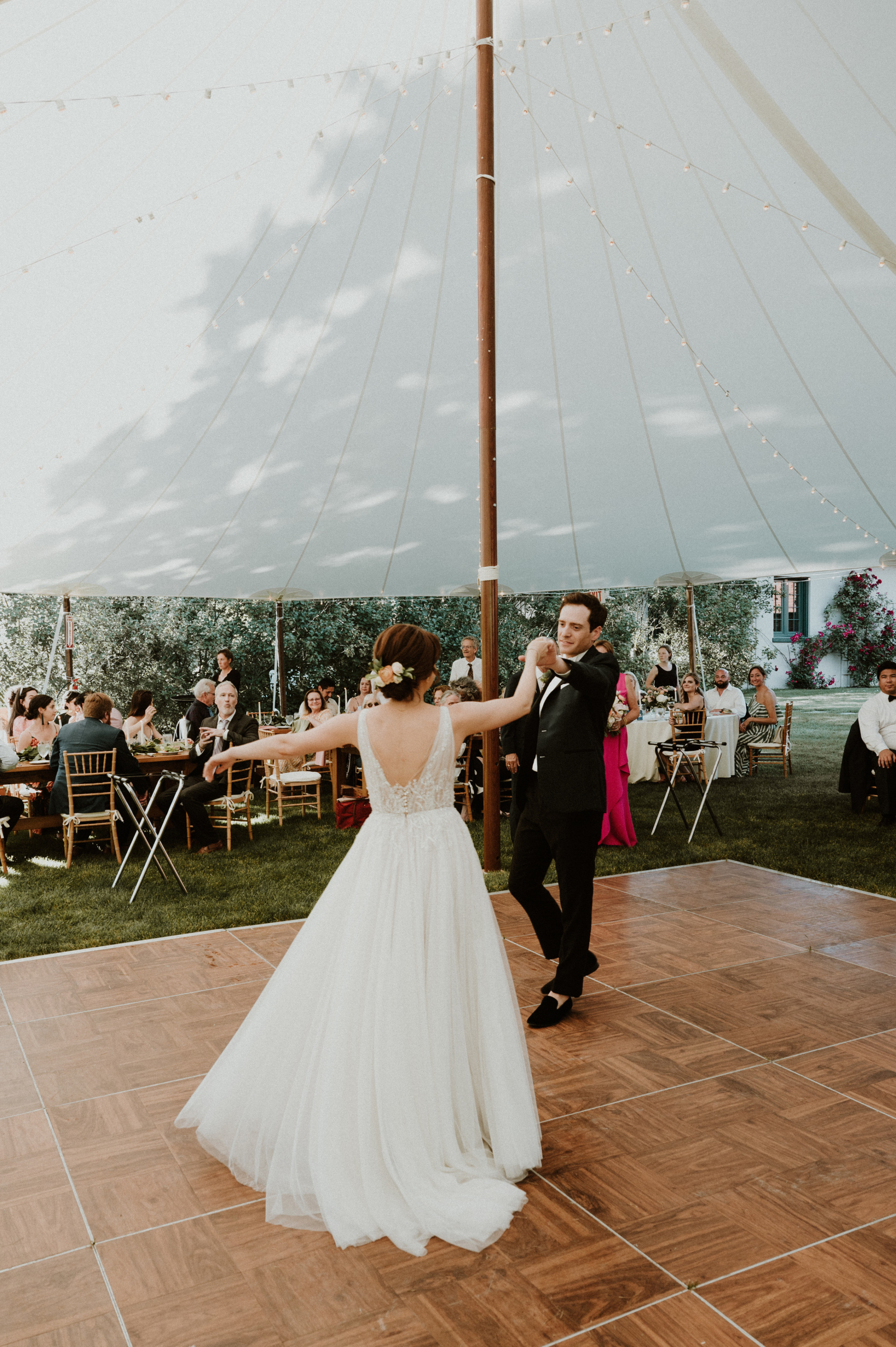 Bride and groom share romantic first dance under elegant white tent at Vermont outdoor wedding.