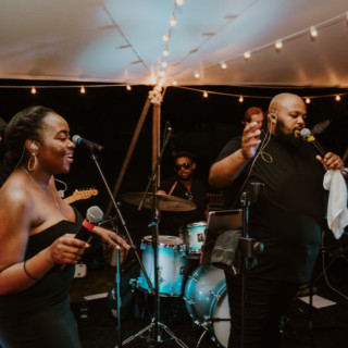 Live wedding band performing under glowing string lights at River Road Farm in Manchester, Vermont.