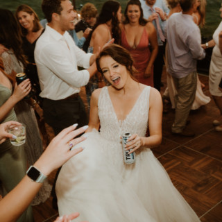 Bride dancing joyfully at River Road Farm wedding reception in Manchester, Vermont.