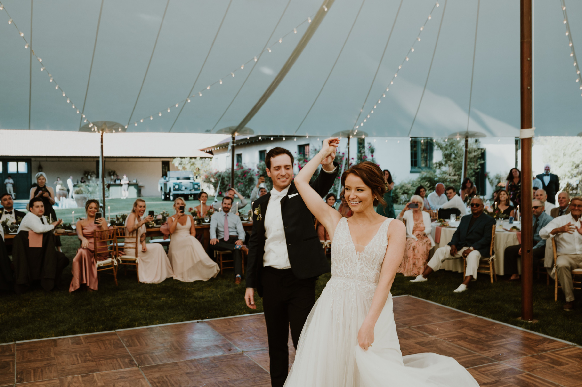 Bride and groom share their first dance under string lights at a romantic Vermont wedding.