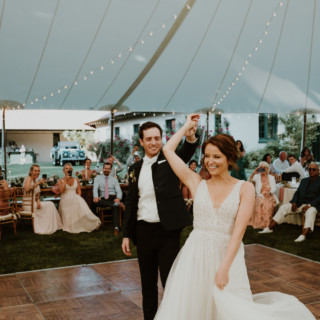Bride and groom share their first dance under string lights at a romantic Vermont wedding.