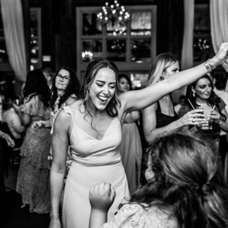Guests dancing and laughing at a joyful black-and-white wedding celebration at The Barn at Gibbet Hill.