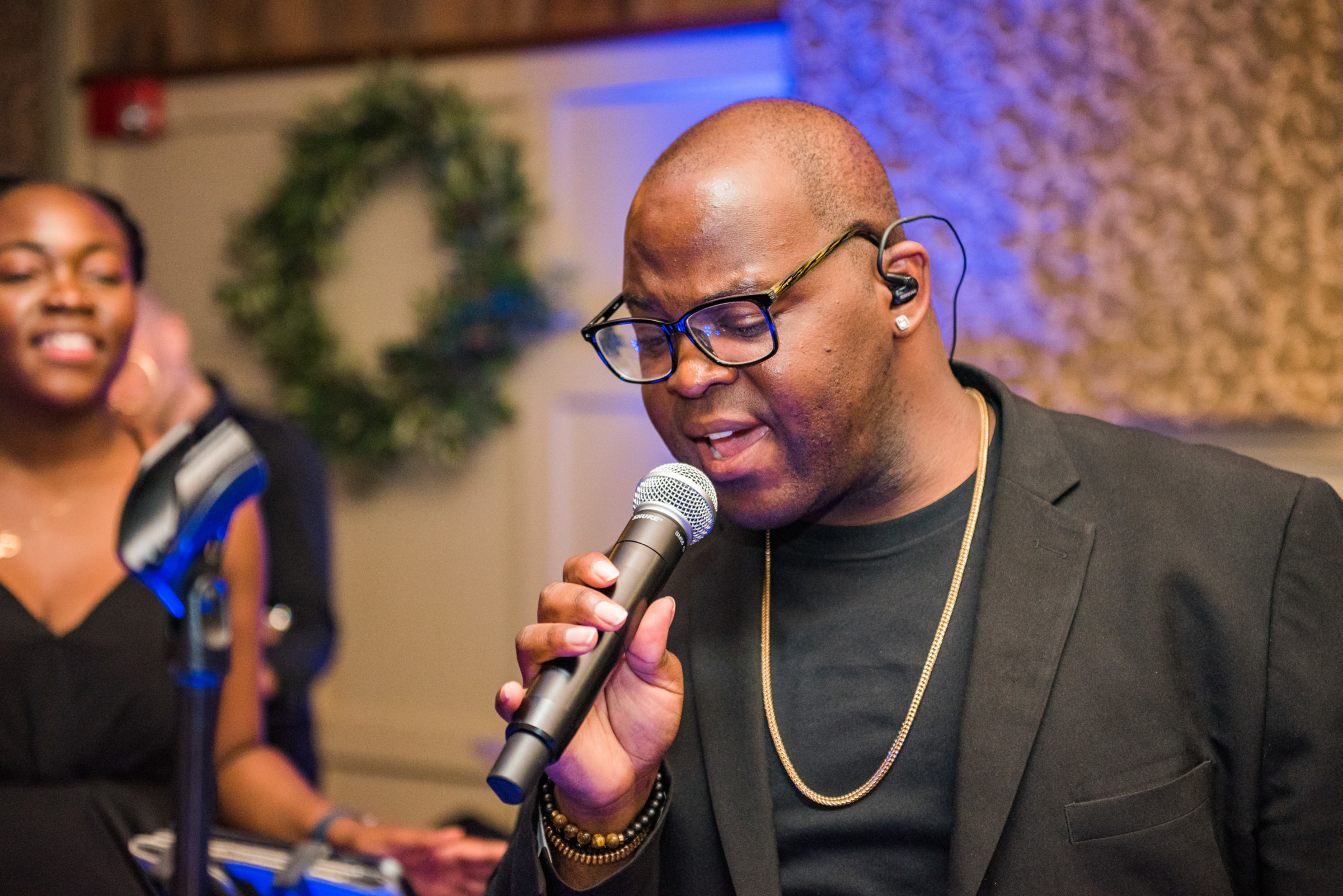 Male singer performing passionately indoors with microphone at The Barn at Gibbet Hill, Groton MA
