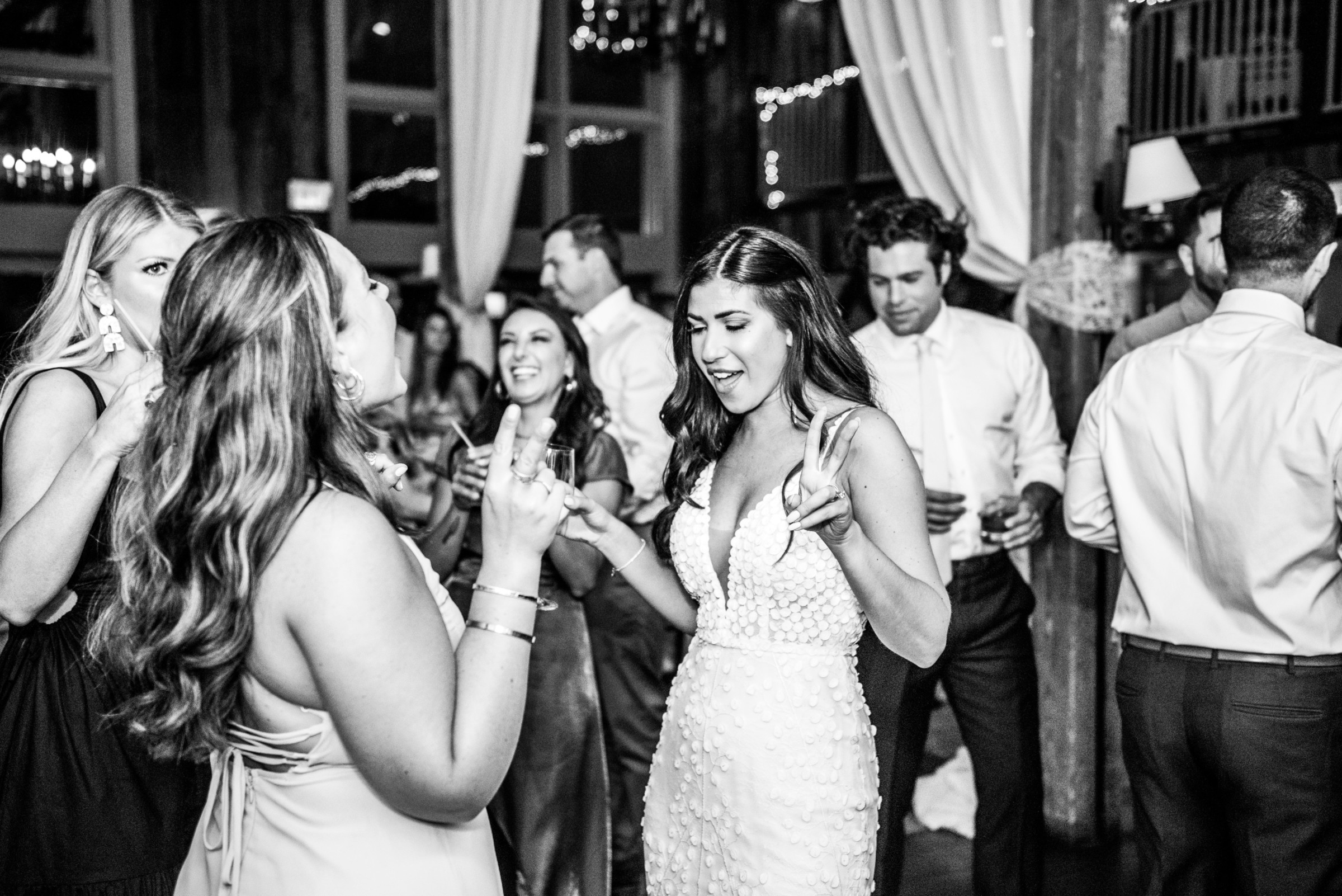 Bride dancing with friends at rustic barn wedding reception in Groton, Massachusetts.
