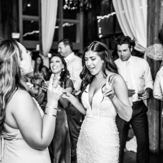Bride dancing with friends at rustic barn wedding reception in Groton, Massachusetts.