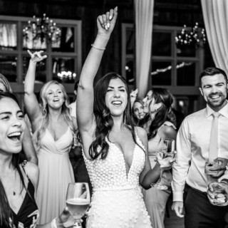 Bride and guests celebrating joyfully at The Barn at Gibbet Hill wedding reception.