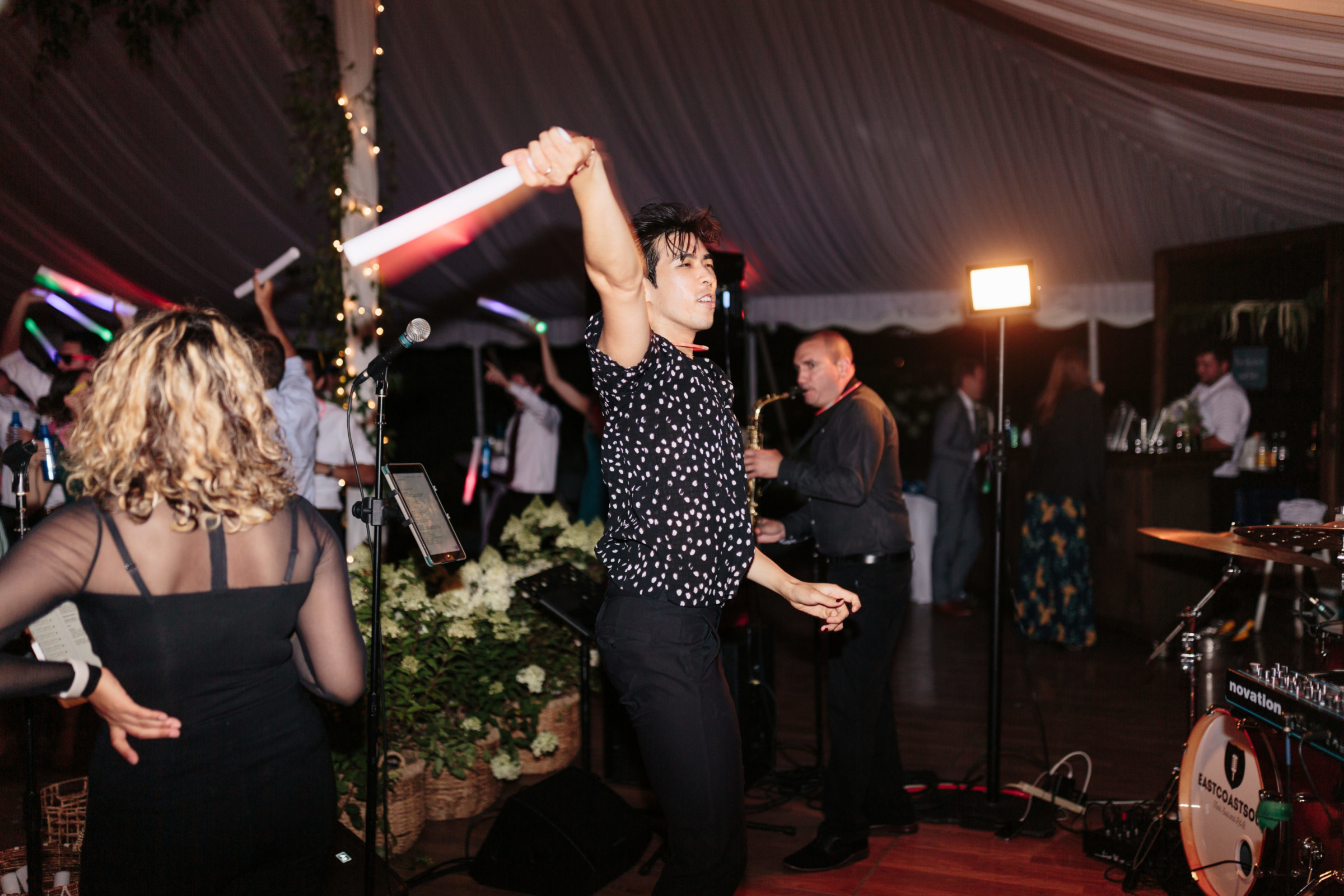 Man dancing with light stick at elegant wedding reception in Stowe, Vermont.