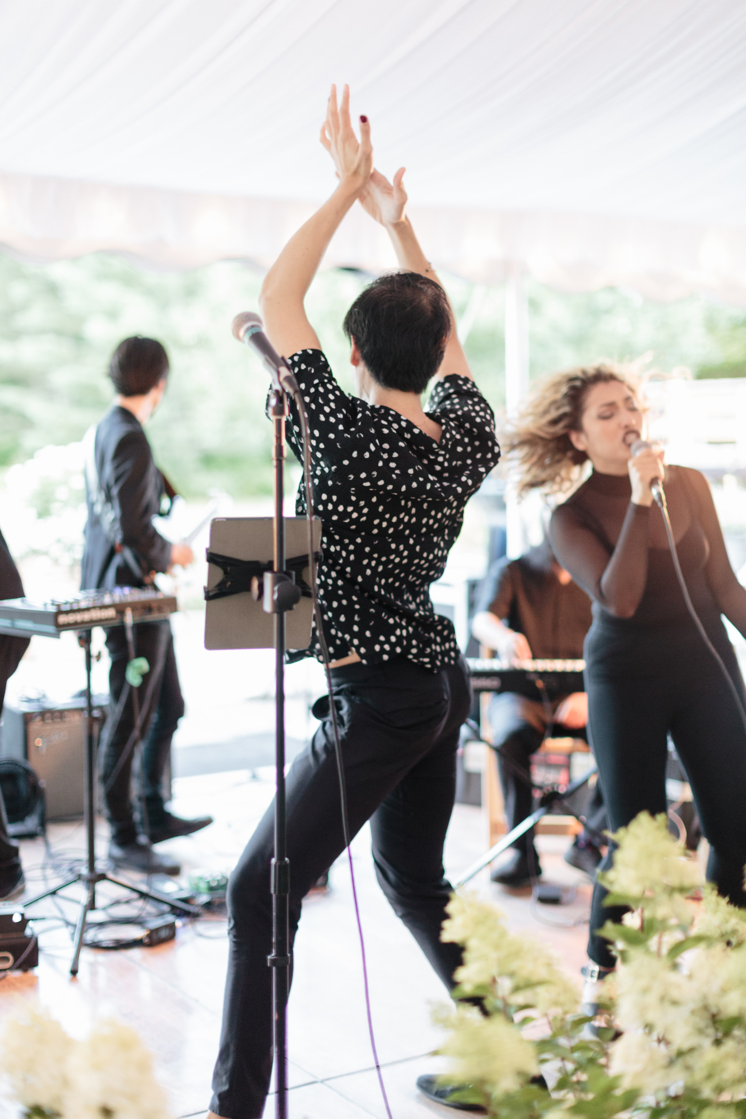 Energetic wedding band performing live under a white tent in Stowe, Vermont.