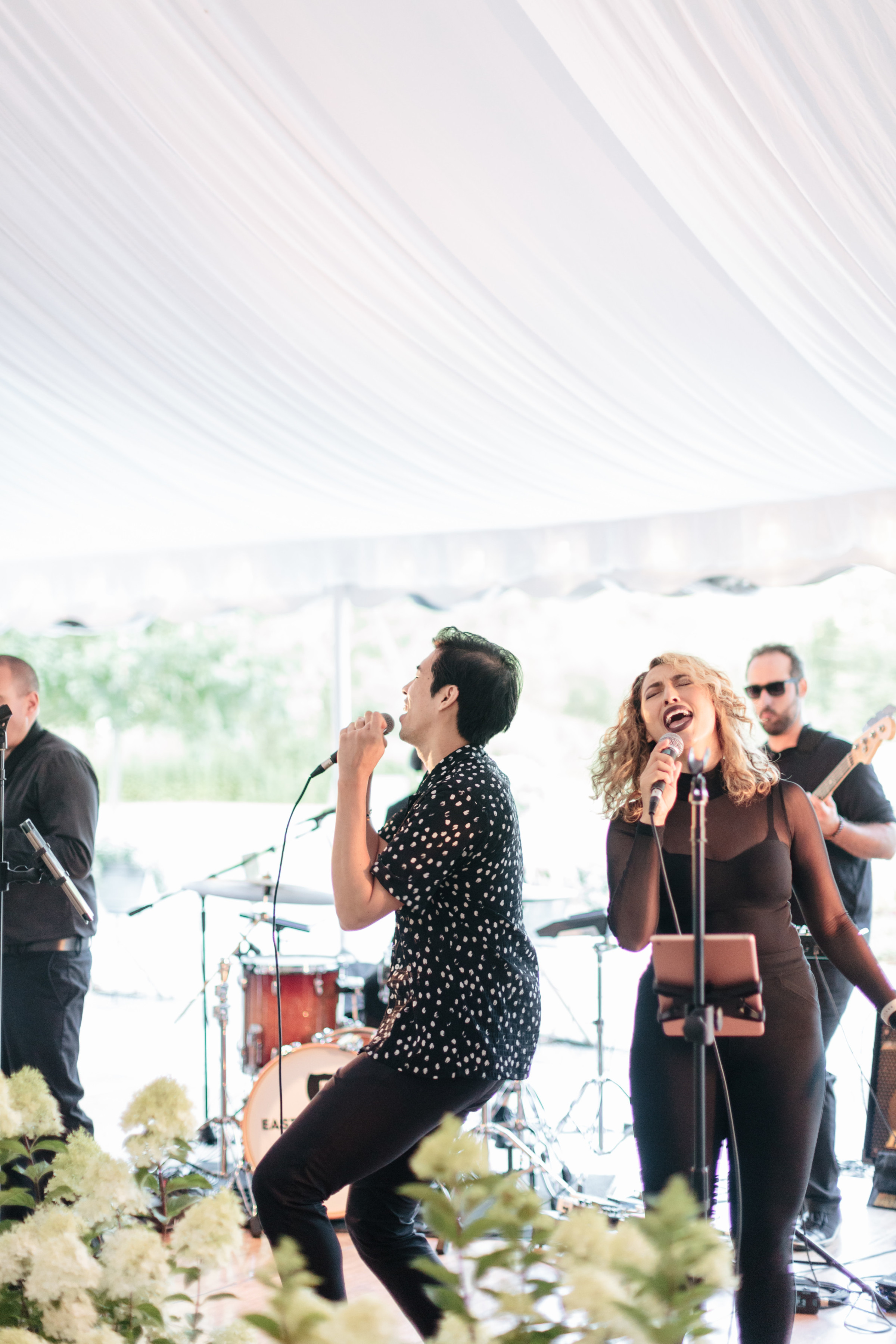 Live band performing under white tent at elegant outdoor wedding in Stowe, Vermont.