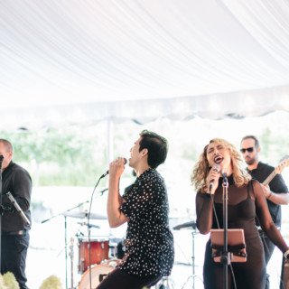 Live band performing under white tent at elegant outdoor wedding in Stowe, Vermont.