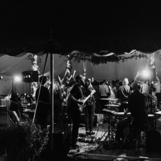 Live band performing at elegant wedding reception under tent in Stowe, Vermont.
