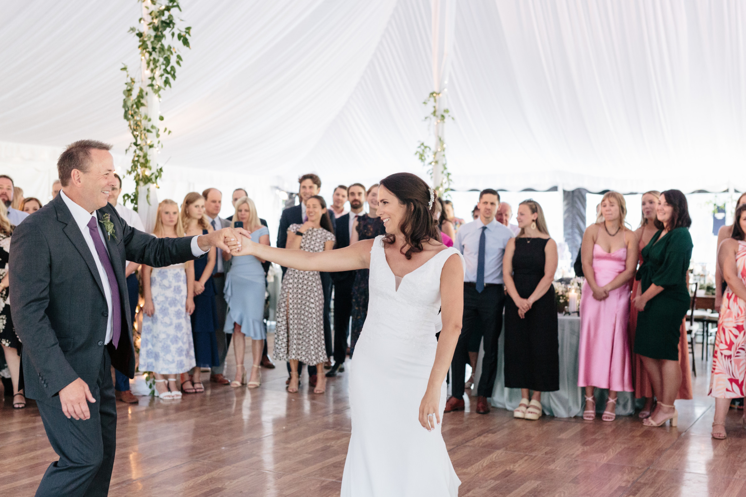 Bride dancing with her father under a white tent at elegant Vermont wedding reception.