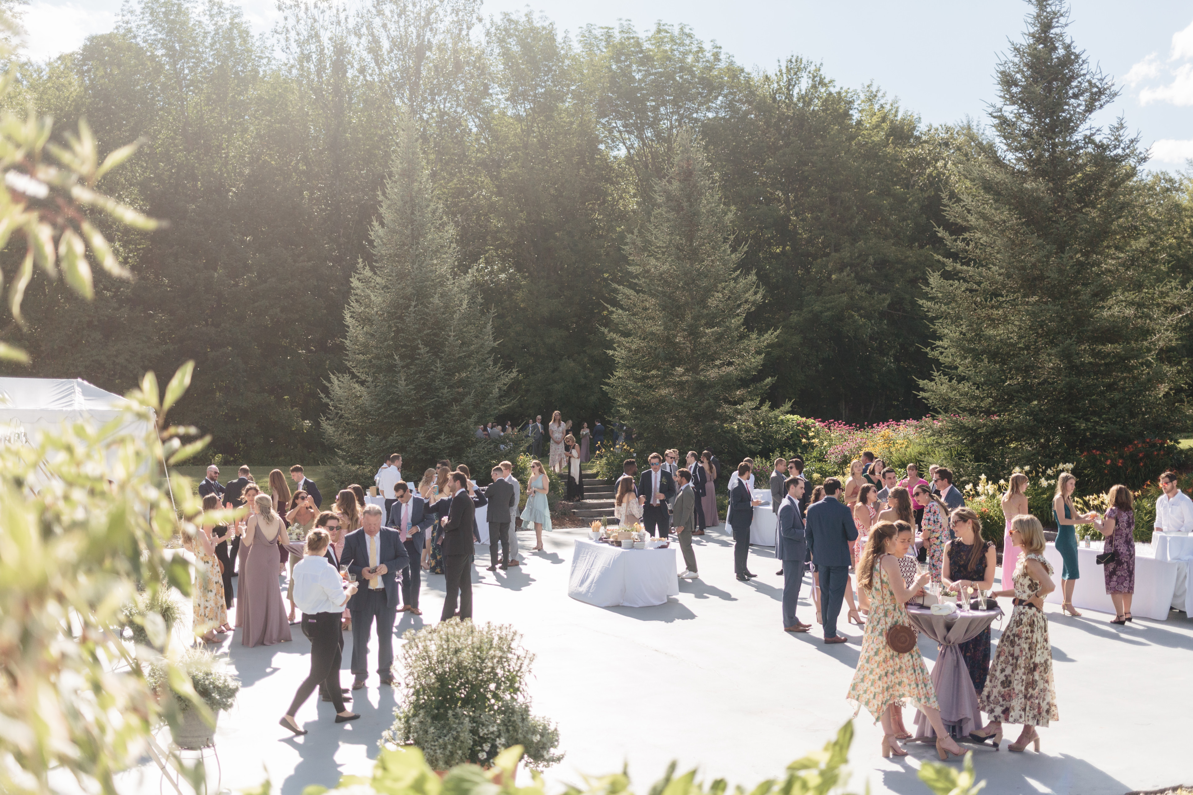 Elegant outdoor wedding reception at Topnotch Resort in Stowe, Vermont, with guests mingling under sunshine.