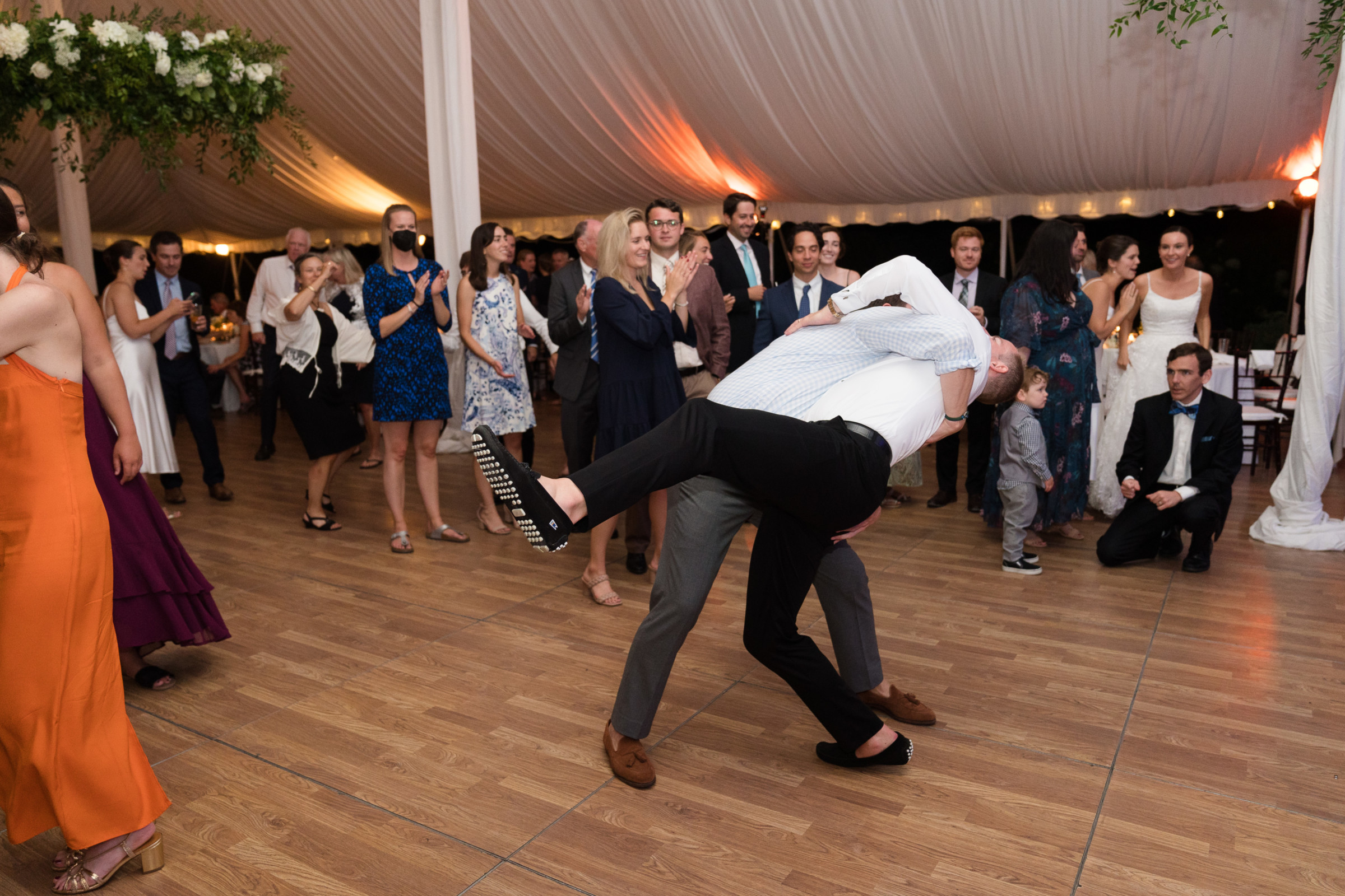 Playful wedding dance dip at Topnotch Resort in Stowe, Vermont under glowing tent lights.