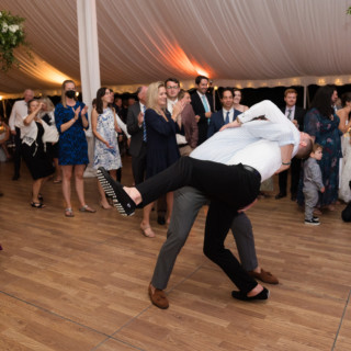 Playful wedding dance dip at Topnotch Resort in Stowe, Vermont under glowing tent lights.