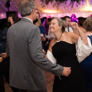 Joyful couple dancing under elegant lights at a Topnotch Resort wedding in Stowe, Vermont.