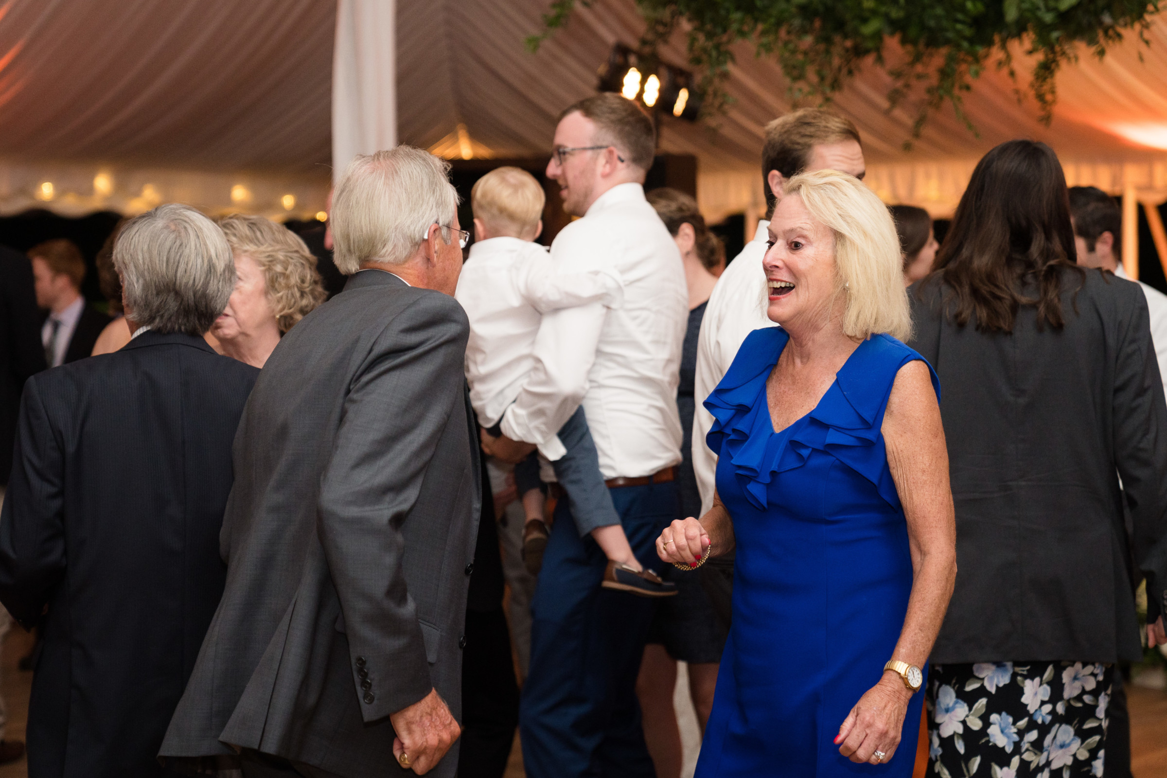 Guests dancing and celebrating under elegant tent lights at a Topnotch Resort wedding in Vermont.