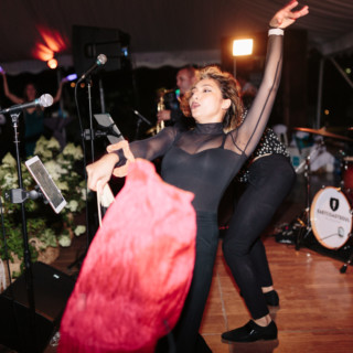 Energetic dancer performing with red cloth during lively wedding celebration at Topnotch Resort, Stowe VT.