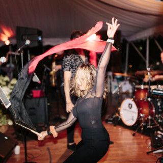 Dancer performing with flowing fabric at lively wedding celebration in Stowe, Vermont.