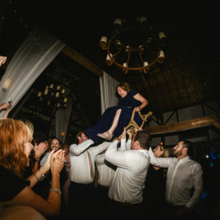 Bride lifted in chair during joyful Hora dance at rustic Valley View Farm wedding.