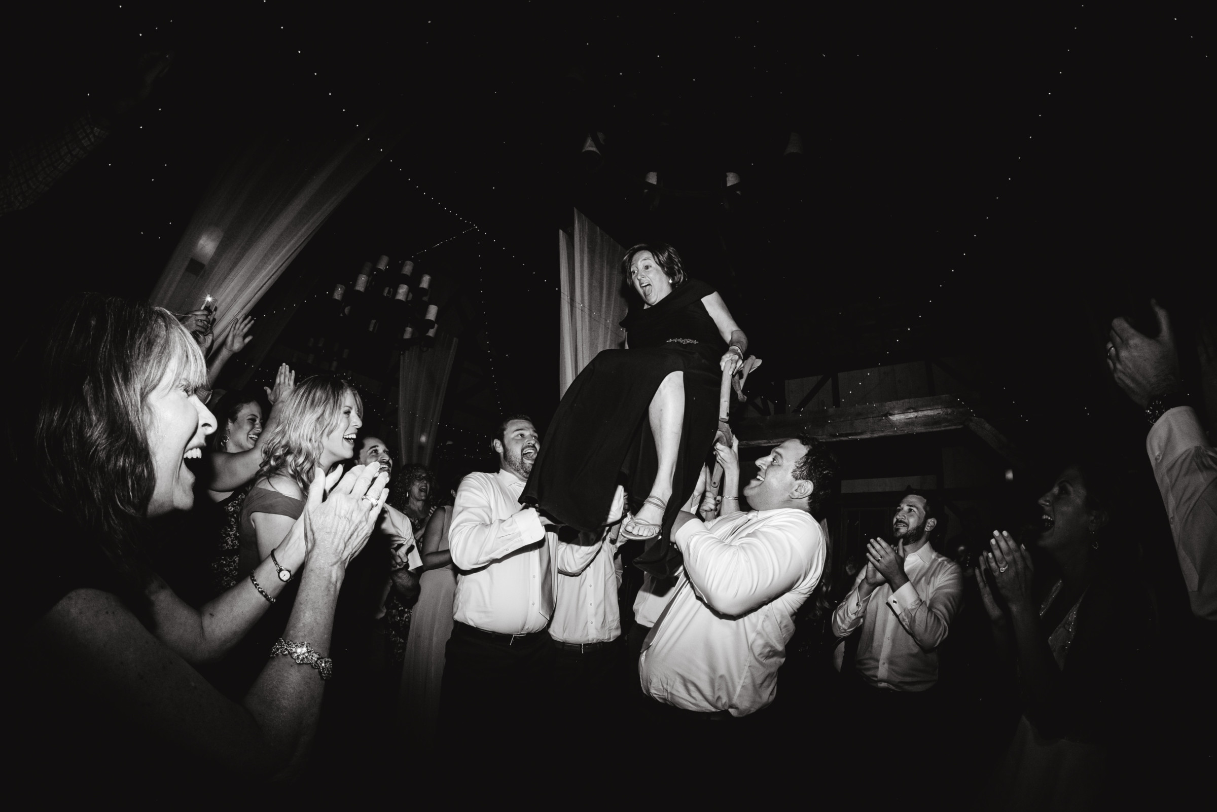 Bride lifted on chair during joyful Valley View Farm wedding celebration in Haydenville, Massachusetts.