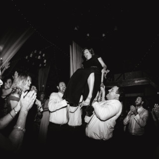 Bride lifted on chair during joyful Valley View Farm wedding celebration in Haydenville, Massachusetts.
