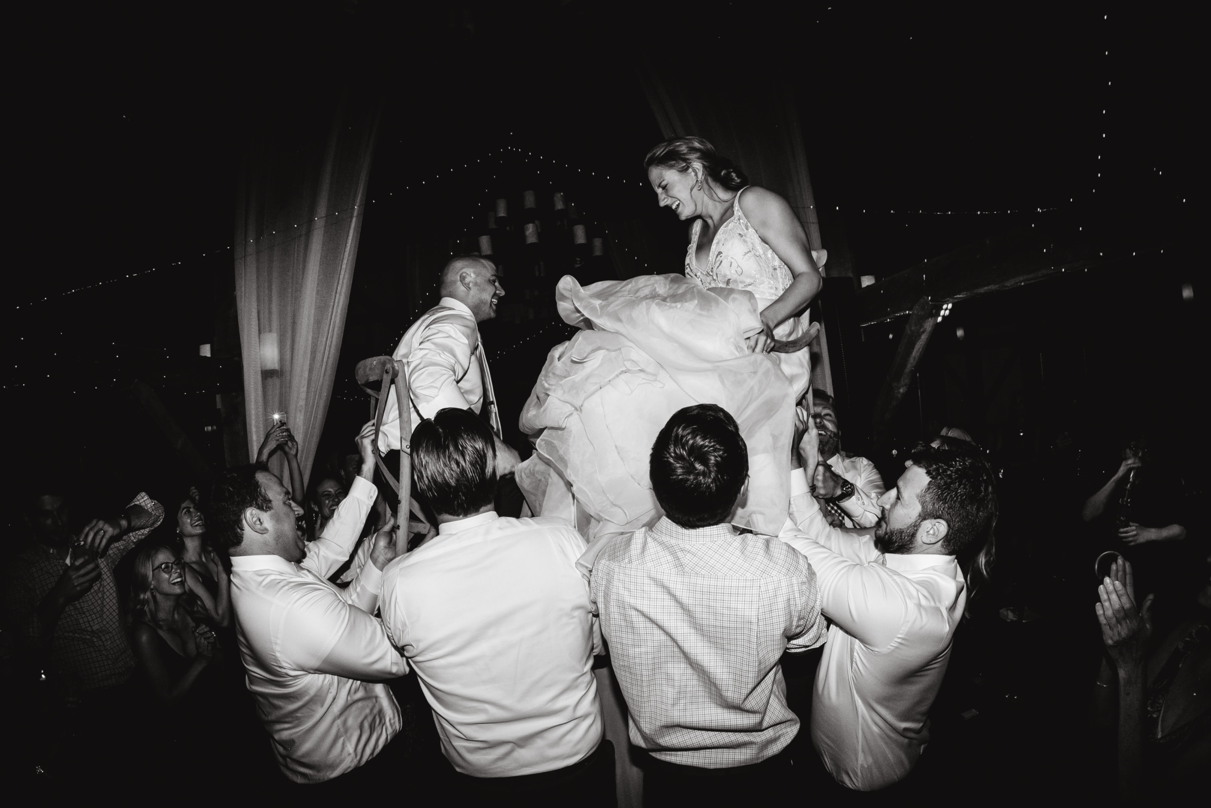 Bride and groom lifted during joyful Hora dance at Valley View Farm wedding celebration.
