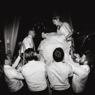 Bride and groom lifted during joyful Hora dance at Valley View Farm wedding celebration.