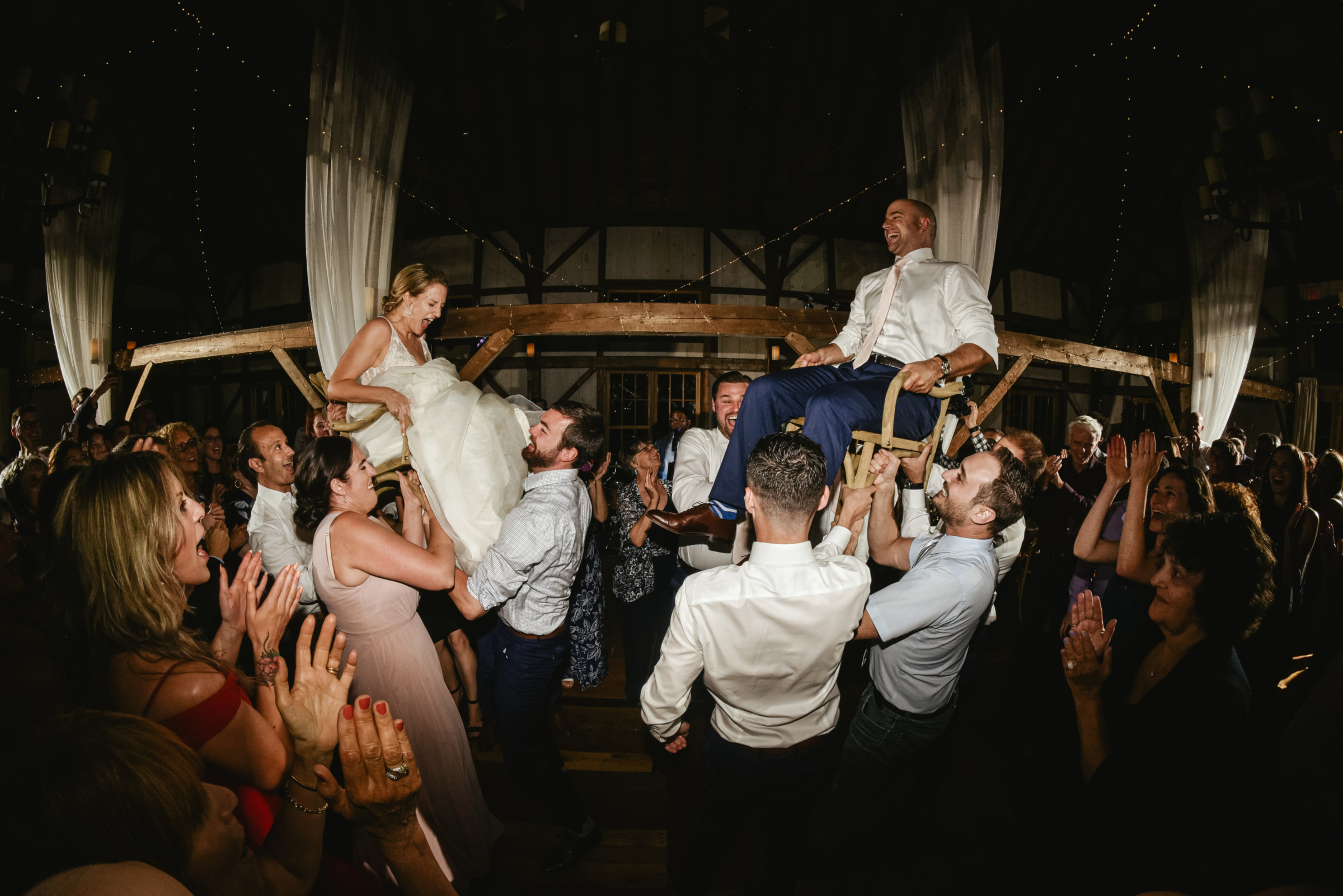 Bride and groom lifted during joyful Hora dance at rustic Valley View Farm wedding.