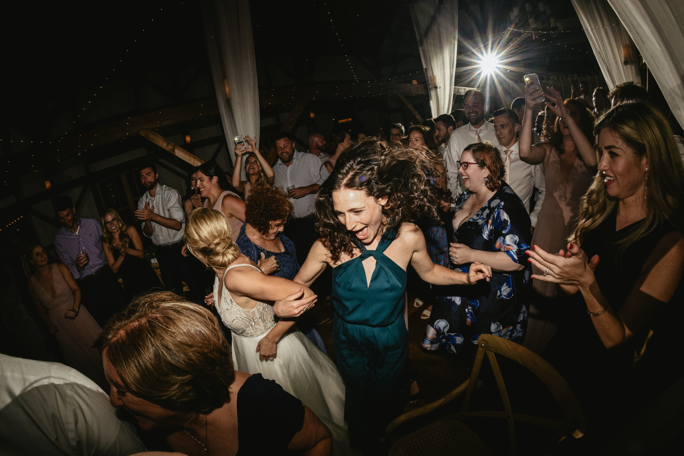 Bride dancing joyfully with guest at rustic Valley View Farm wedding in Haydenville, Massachusetts.