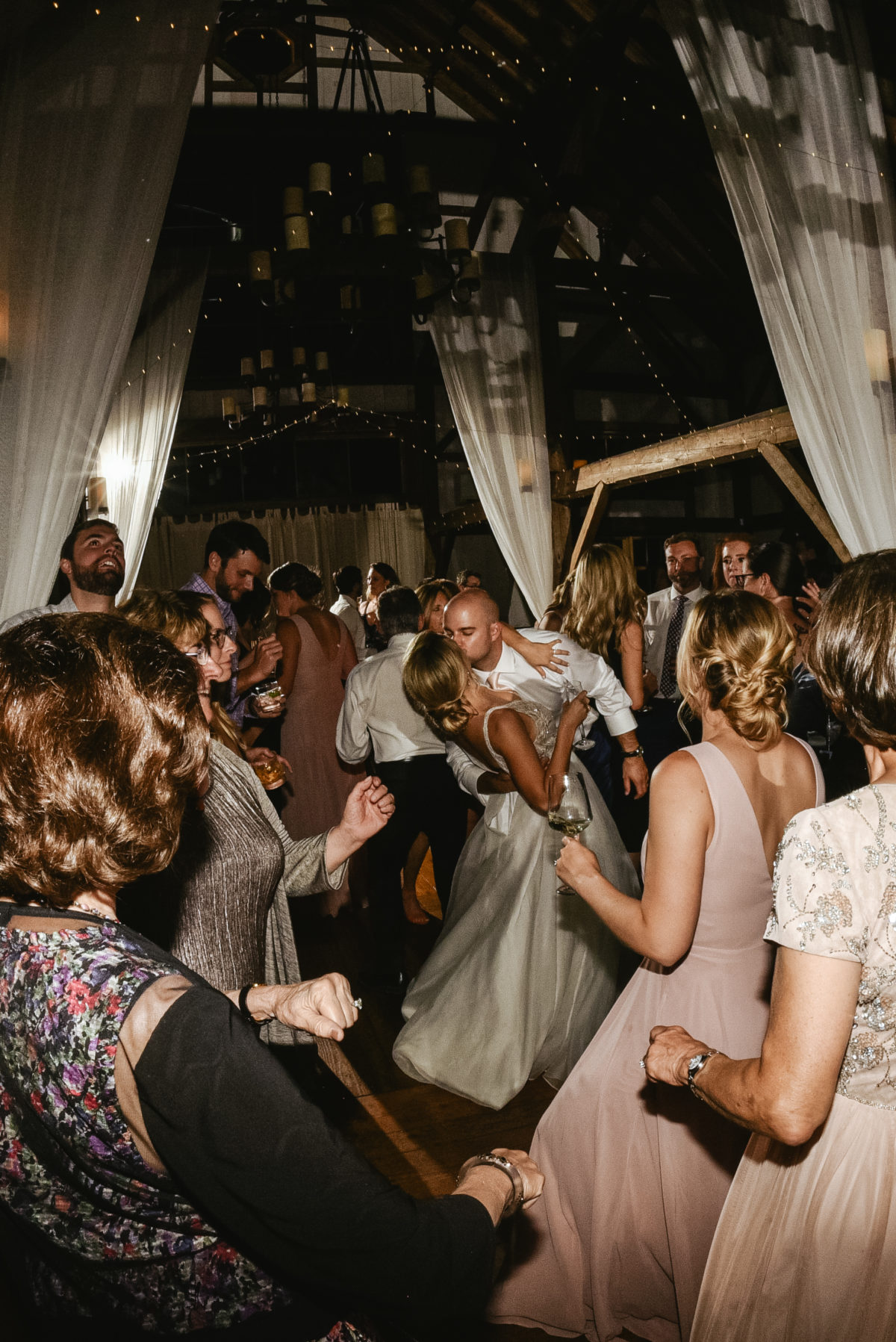 Bride and groom share a romantic dip and kiss during their Valley View Farm wedding reception.